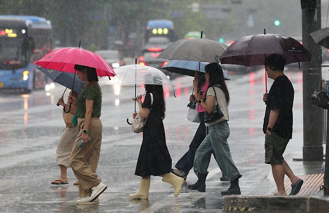 장마철 답지 않은 폭우가 잦아졌다. 최근 서울 광화문 네거리에서 직장인들이 레인부츠나 슬리퍼 차림으로 출근하는 모습. /뉴스1