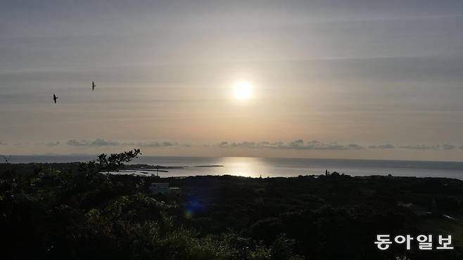 섬에서 가장 높은 해발 97m 언덕 하지피키파탄(舵引き丘)에서 바라본 남쪽 바다. 낙조가 시작되고 있다. 왼쪽 저 멀리 7개 봉우리가 이어진 이헤야(伊平屋)섬이 보인다.