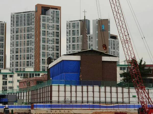 최근 오전 인천 부평구 삼산동 한 대규모 아파트 건설 공사 현장 옆 교회 외벽이 파란색 가림막으로 가려져 있다. 황남건기자