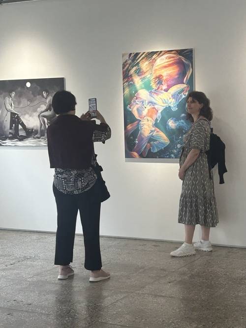 서울 성동구 택사서울에서 열리는 BTS팬아트 전시 ‘부재 속 존재: 챕터 2 BTS 아트’전시를 찾은 해외 아미가 작품 앞에서 사진을 찍고 있다. 사진제공=25th Hour Collective