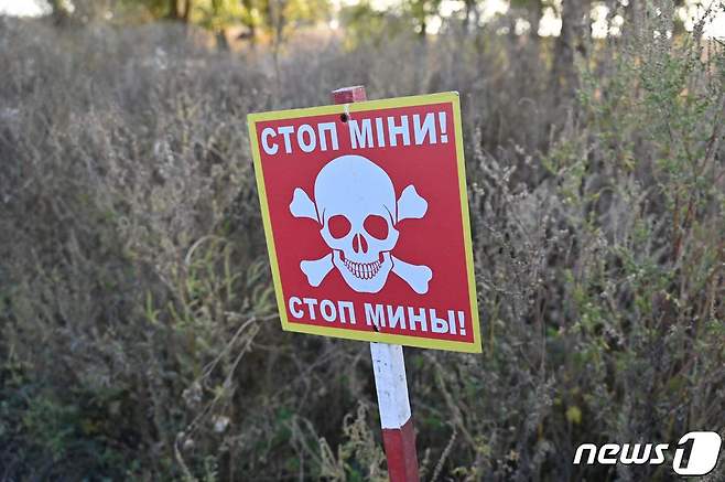 우크라이나 하르키우의 한 마을에서 포착됨 지뢰 안내문. 표지에는 "멈추라, 지뢰"라고 적혀져 있다. 2023.09.29. ⓒ AFP=뉴스1 ⓒ News1 정윤영 기자