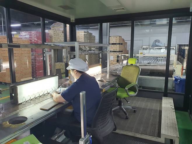 한 직원이 용기 전수 검사를 하고 있다. 안성=윤현주 기자