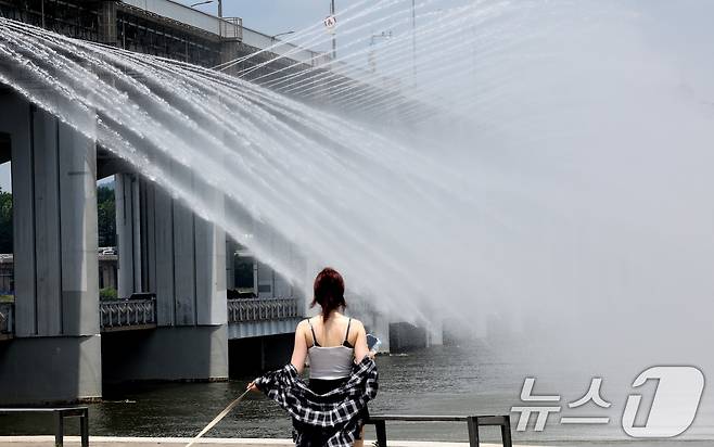 서울 전역에 폭염주의보가 발령된 30일 오후 서울 서초구 반포한강공원에서 시민들이 반포대교 달빛무지개분수를 바라보며 더위를 식히고 있다. 2025.6.30/뉴스1 ⓒ News1 이동해 기자