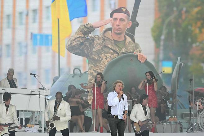 영국 유명 록 가수 로드 스튜어트가 29일 영국 글래스톤베리 페스티벌 마지막 날 피라미드 무대에서 우크라이나군을 배경으로 공연을 펼치고 있다. /연합뉴스