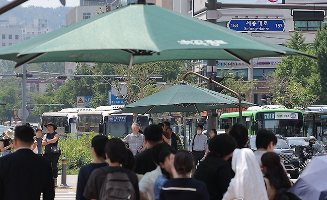 지난 23일 서울 광화문광장 횡단보도에서 시민들이 그늘막 아래서 보행 신호를 기다리고 있다. ⓒ연합뉴스