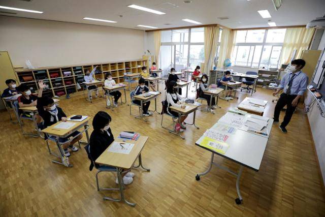 일본 초등학생들이 코로나19 사태 때인 2020년 6월 1일 도쿄 한 초등학교 교실에 일정 거리를 둔 채 앉아 있다. 도쿄=지지·AFP 연합뉴스