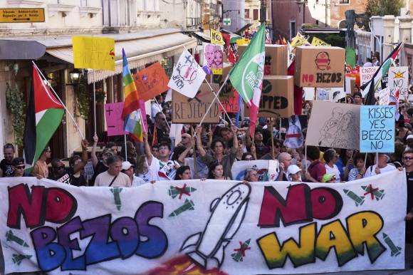 28일(현지시간) ‘베이조스 반대’를 의미하는 문구가 적힌 현수막을 들고 결혼식을 규탄하며 베네치아 도심을 행진하는 시위대. 베네치아 AP 연합뉴스