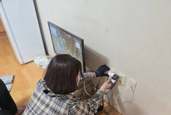 시 관계자가 전력 감지형 ‘스마트돌봄플러그’를 설치하고 있다.