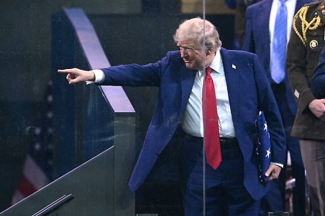 도널드 트럼프 미국 대통령이 지난 14일 육군 창설 250주년 행사에서 미국 국기를 향해 가리키는 포즈를 취하고 있다. /AFP연합뉴스