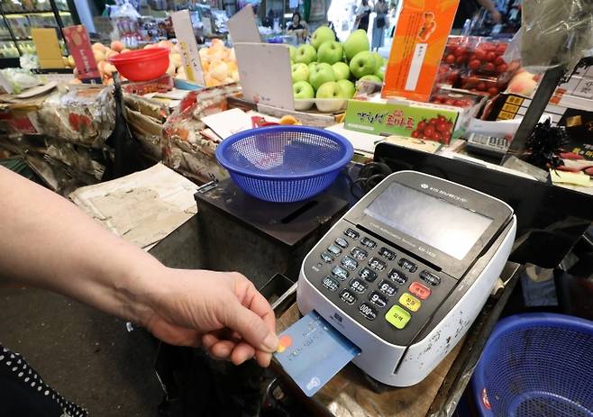 ▲서울 마포구 망원시장의 한 점포에서 점주가 신용카드로 물건값을 결제하고 있다./사진=뉴시스