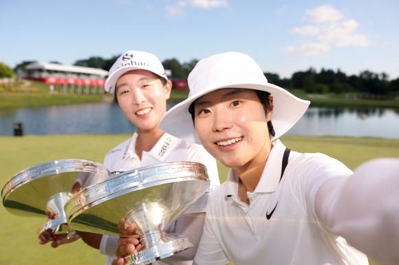 임진희(왼쪽)와 이소미(오른쪽)가 30일(한국시간) 미국 미시간주 미들랜드 컨트리클럽에서 막을 내린 미국여자프로골프(LPGA) 투어의 유일한 2인 1조 대회 다우 챔피언십에서 데뷔 첫 승을 올린 뒤 우승컵을 들고 환하게 웃으며 ‘셀카’를 찍고 있다. 미들랜드 AFP 연합뉴스