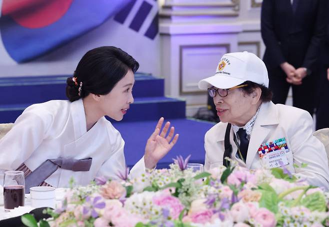 이재명 대통령과 김혜경 여사가 27일 청와대 영빈관에서 열린 ‘호국 보훈의 달, 대통령의 초대’ 행사에서 6·25전쟁에 참전해 유격대원으로 활약했던 여성 참전유공자 이춘자 참전용사와 대화하고 있다. (사진=연합뉴스).