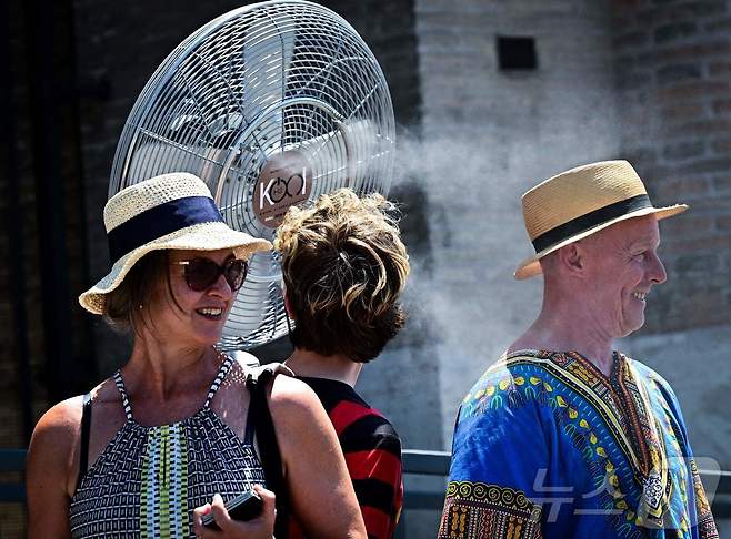 1일(현지시간) 이탈리아 로마 콜로세움 인근에서 관광객들이 선풍기 앞에 서 있다. ⓒ AFP=뉴스1