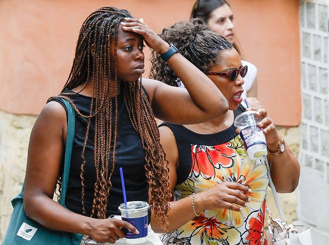 서울 최고온도 33도까지 올라 습하고 더운 날씨를 보인 2일 서울 종로구 북촌한옥마을에서 한 외국인 관광객이 이마의 땀을 닦고 있다.