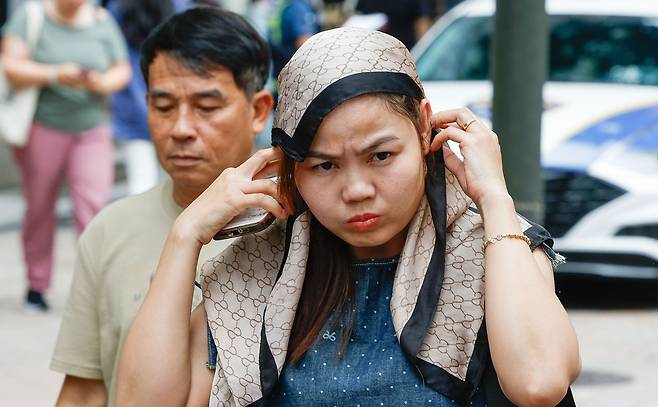 서울 최고온도 33도까지 올라 습하고 더운 날씨를 보인 2일 서울 중구 명동 거리에서 한 외국인 관광객이 스카프로 더위를 피하고 있다.