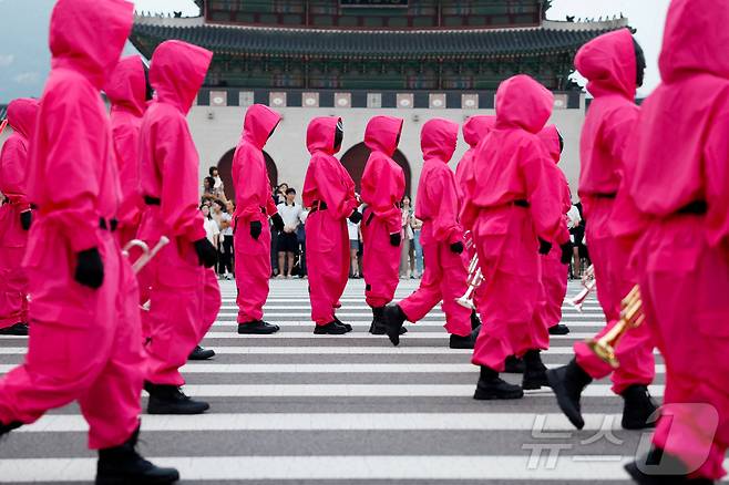 지난 28일 서울 광화문광장에서 열린 '오징어 게임 3' 홍보 행사에서 캐릭터로 분장한 사람들이 행진을 하고 있다. ⓒ 로이터=뉴스1