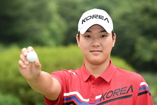 김민수가 골프공을 들고 포즈를 취하고 있다.