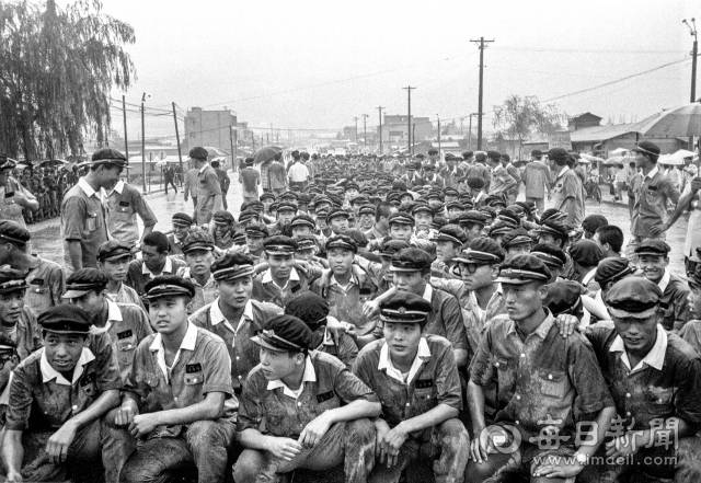 1969년 7월 10일 낮 12시쯤 비가 내리는 가운데 3선 개헌 반대 가두 데모에 나선 대구고 학생들이 2·28기념탑이 있는 명덕로타리로 진출하다 출동한 경찰과 교사들의 제지에 막혀 도로에서 연좌데모를 벌이고 있다. 사진=매일아카이빙센터