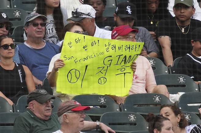 A baseball fan holds sign that reads "hit! Hit! Fly over Jung Hoo Lee" for San Francisco Giants' Jung Hoo Lee, of South Korea, during the eighth inning of a baseball game between the San Francisco Giants and the Chicago White Sox in Chicago, Sunday, June 29, 2025. AP연합뉴스