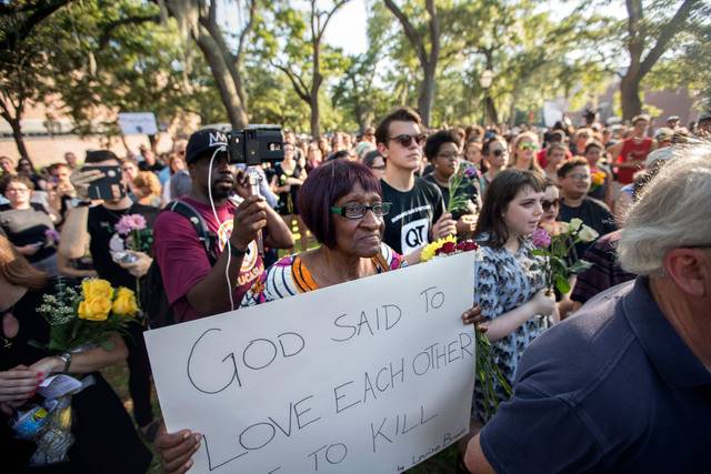 인종 차별 반대 시위대가 2015년 6월 미국 사우스캐롤라이나주 찰스턴의 흑인 교회 인근에서 백인우월주의 청년이 저지른 총기 난사 사건을 애도하며 행진하고 있다. 한 참가자가 “하나님은 서로 사랑하라고 말씀했다”고 적힌 팻말을 들고 있다. AP뉴시스
