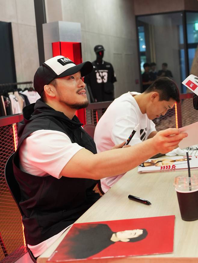 유수영(사진 왼쪽)과 유주상이 팬들에게 사인을 해주며 인사를 건네고 있다. UFC 제공