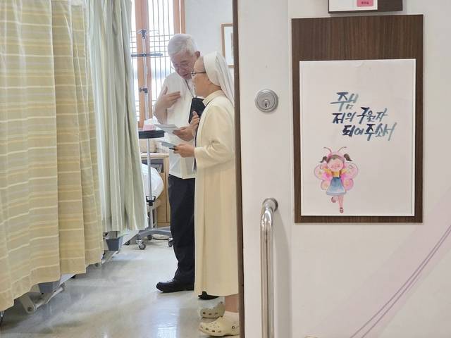 원목자가 기도와 성가를 통해 환자와 가족의 마음을 위로하며 영적 돌봄을 하고 있다.