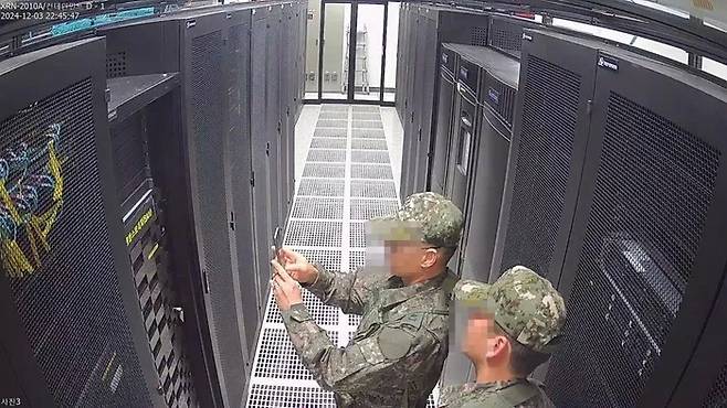 지난 3일 중앙선거관리위원회 과천 청사 전산실 서버에서 계엄군이 사진을 촬영하고 있다. 행정안전부 제공