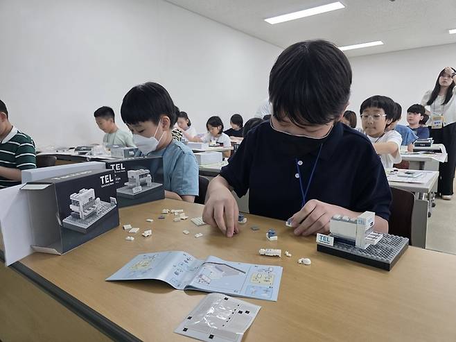 참가자들이 도쿄일렉트론 식각 장비 'Tactras' 블록 모형을 조립하고 있다.