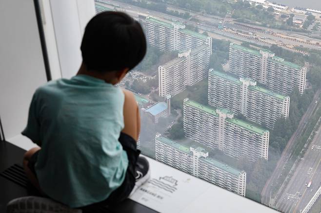 집값, 잡을 수 있을까 6일 서울 송파구 롯데월드타워 전망대에서 한 아이가 아파트와 빌라가 빼곡하게 들어선 잠실 일대를 내려다보고 있다. 연합뉴스