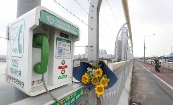 서울 마포대교에 설치된 생명의 전화 옆에 꽃다발이 놓여져 있다. 뉴스1