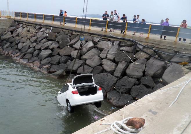 렌터카 바다로 추락…가족 3명 부상 (서귀포=연합뉴스) 7일 오후 제주 서귀포시 안덕면 사계항에서 해경 등이 바다로 추락한 렌터카를 인양하고 있다. 이 사고로 박모(45ㆍ여)씨 등 가족 3명이 다쳤다. 2012.6.7 <<서귀포해양경찰서>> koss@yna.co.kr