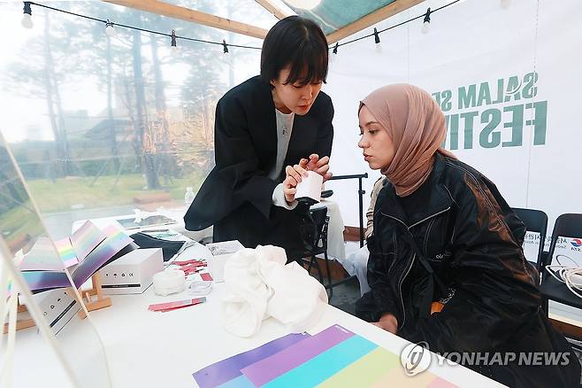 나에게 어울리는 히잡 찾기 (서울=연합뉴스) 진연수 기자 = 지난해 10월 22일 오후 서울 종로구 광화문 광장에서 열린 '살람 서울 페스티벌'에서 외국인 관광객이 히잡 퍼스널 컬러 테스트를 받고 있다. 2025.7.6 jin90@yna.co.kr