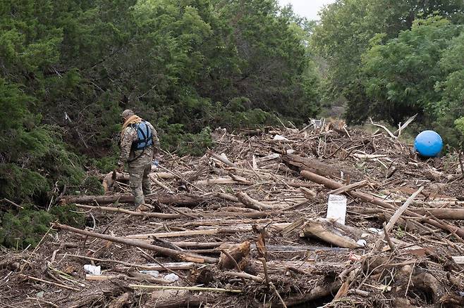 미국 국경순찰대원들이 6일(현지시각) 텍사스 커빌에서 과달루페 강을 따라 홍수 잔해물을 수색하고 있다. AFP 연합뉴스