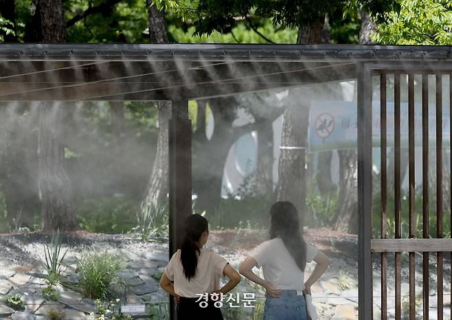 서울의 한낮 체감온도가 33도까지 오르는 등 무더위가 이어지고 있는 지난 1일 서울 여의도공원에서 시민들이 쿨링포그 벤치에 앉아 더위를 피하고 있다. 문재원 기자