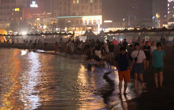 열대야가 이어진 7일 오후 부산 광안리해수욕장에서 시민들이 시원한 바닷바람을 맞으며 산책하고 있다. 연합뉴스