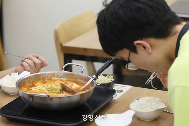 혜화점에서 한 손님이 김치찌개를 먹고 있다.