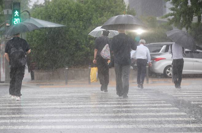 서울 서남권에 호우주의보가 발효된 8일 서울 영등포구 여의도 국회 인근에서 시민들이 우산을 쓰고횡단보도를 건너고 있다. 연합뉴스