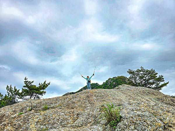 산방산의 전망바위를 오른다. 뒤로 산방산 정상부의 암봉이 보인다.