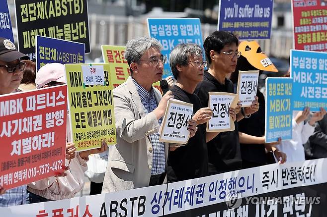 '홈플러스 전단채 피해자' 진정서 제출 기자회견 (서울=연합뉴스) 윤동진 기자 = 12일 서울 전쟁기념관 앞에서 열린 '홈플러스 전단채 사기발행 사건 관련, MBK 엄벌과 피해회복을 위한 진정서 제출 기자회견'에서 홈플러스 물품 구매 전단채 피해자 비상대책위원회 등 참석자들이 관련 내용이 적힌 피켓을 들고 있다. 2025.6.12 mon@yna.co.kr