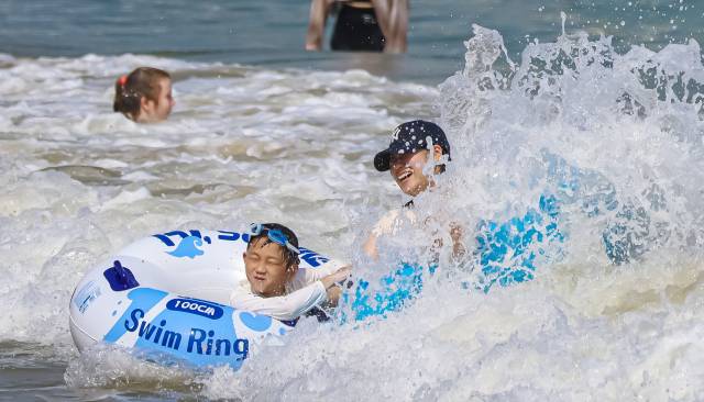 무더위가 이어진 9일 부산 수영구 광안리 해수욕장을 찾은 관광객들이 해수욕을 즐기고 있다. 김종진 기자 kjj1761@