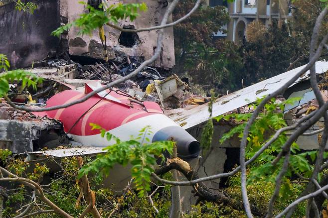 6월 14일(현지시간) 인도 아메다바드 공항 인근 주거지역에서 크레인이 6월 12일 발생한 인도항공 171편 추락 사고의 잔해 속에서 항공기 꼬리 부분을 제거하고 있다. 조사관들은 런던행 여객기가 인도 아메다바드 시의 주거지역으로 추락해 탑승자 및 지상에 있던 최소 265명이 사망한 사고 현장에서, 6월 13일 블랙박스 기록 장치를 회수했다.(사진=AFP)