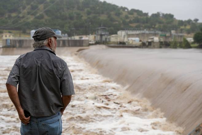 4일(현지시간) 미국 텍사스주 중부 커 카운티 케르빌 지역 주민이 과달루페 강의 수위가 높아지는 모습을 지켜보고 있다. 2025.7.5 텍사스 AFP 연합뉴스
