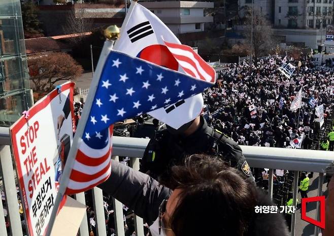 지난 1월 3일 아침 윤석열 대통령에 대한 체포영장 집행을 위해 공수처 관계자들이 서울 한남동 대통령 관저에 들어간 가운데 윤 대통령 지지자들이 관저 근처 집회장으로 가면서 태극기와 성조기, 부정선거 검증을 촉구하는 손팻말을 들고 구호를 외치고 있다. 허영한 기자
