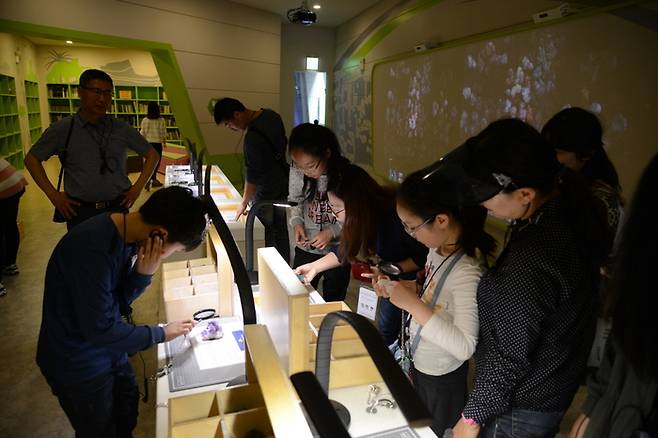 지질박물관을 방문한 학생들이 광물 시료를 관찰하며 체험 활동을 하고 있다.