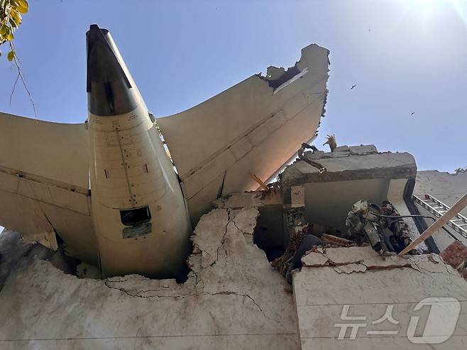 인도 에어인디아 소속 보잉 787드림라이너 여객기가 12일(현지시간) 인도 서부 아메다바드 공항 인근에서 추락했다. 사진은 추락한 건물 꼭대기에 기체 꼬리가 박힌 모습. 2025.06.12 ⓒ 로이터=뉴스1 ⓒ News1 최종일 선임기자
