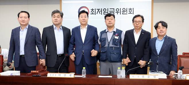 최저임금위원회 이인재 위원장과 권순원 공익위원, 류기정 사용자 위원, 류기섭 근로자 위원 등이 지난 10일 밤 세종시 정부세종청사에서 2026년도 적용 최저임금안을 합의로 결정한 뒤 손을 맞잡고 있다. 내년도 최저임금은 1만 320원으로 결정됐다. 2024.07.11. /사진=뉴시스