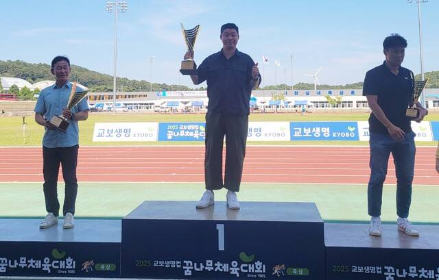 2025 교보생명컵 전국초등학교 시·도대항육상대회서 종합우승 34연패를 달성한 경기도 선수단 조현민 총감독(가운데)이 시상대 가장 높은 곳에서 우승트로피를 들고 기념촬영을 하고 있다.경기도육상경기연맹 제공