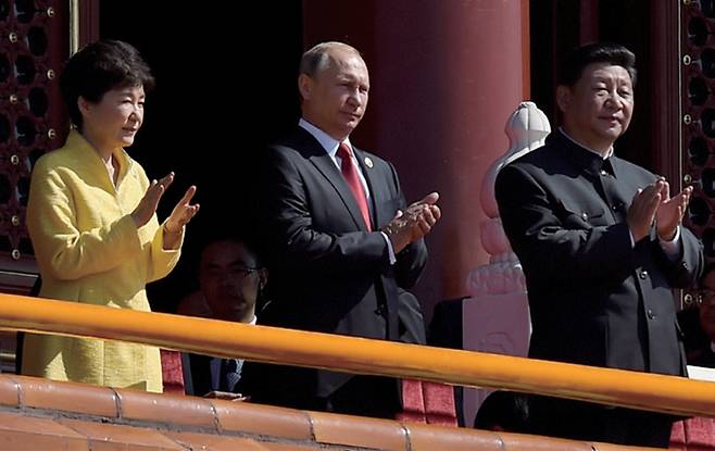 2015년 9월3일 일본의 제2차 세계대전 항복 70주년을 기념하는 군사 퍼레이드에서 당시 한국의 박근혜 대통령(왼쪽)이 블라디미르 푸틴 러시아 대통령(가운데), 시진핑 중국 국가주석(오른쪽)과 함께 박수를 치고 있다. ⓒAP 연합