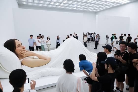 호주 출신 조각가 론 뮤익의 ‘침대에서’. 가로 6m50㎝ 크기를 자랑하는 이 작품은 야외 포스터를 장식했다. 우상조 기자