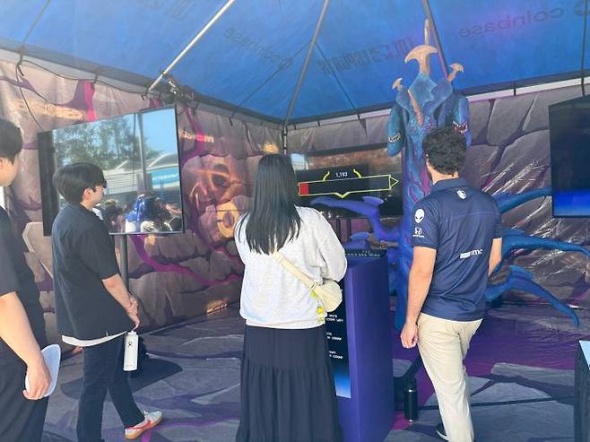코인베이스의 현장 부스를 방문한 관람객. 바론의 피가 1200에 도달할 때 버튼을 누르면 미션 성공이다. ⓒ데일리안 황지현 기자